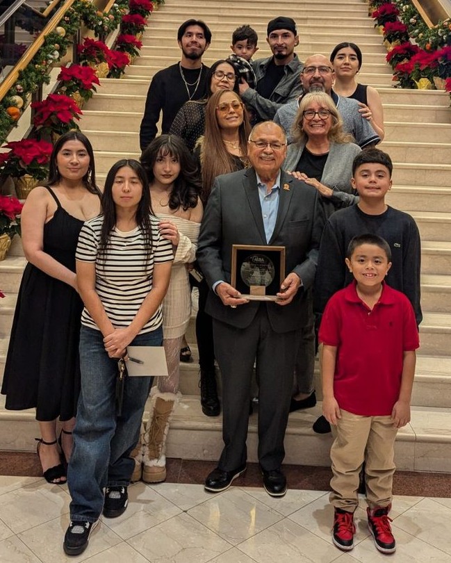 Harry Garewal centered with his family while holding the Barbara B. Robey Lifetime Achievement Award