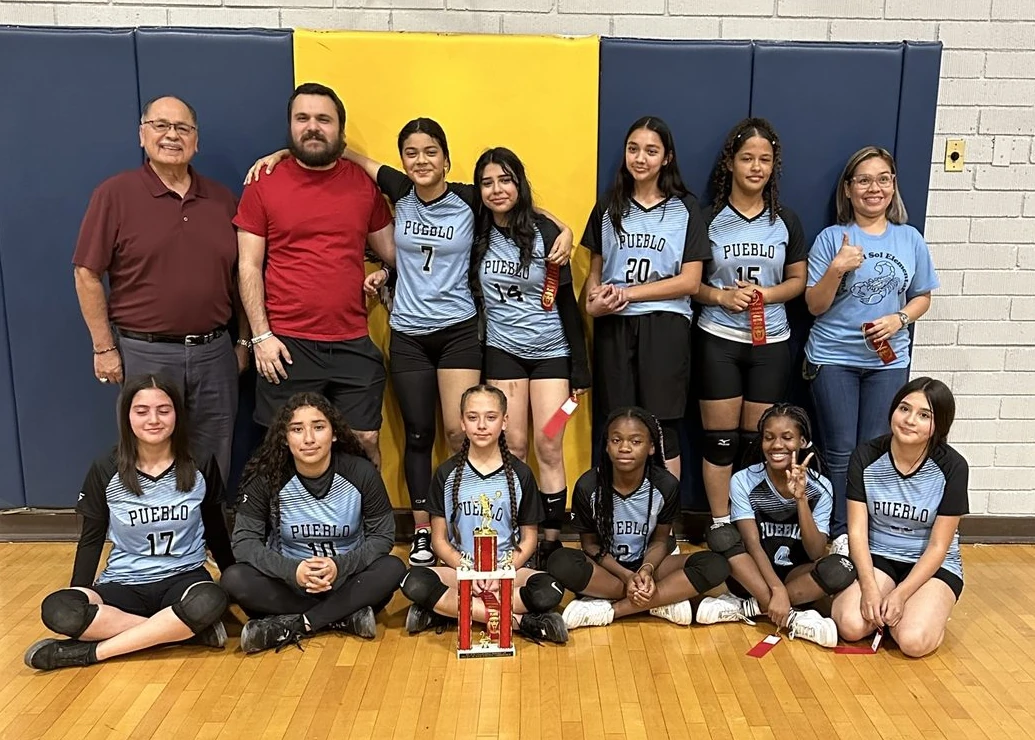 Harry Garewal with the Pueblo junior-high girls volleyball team and trophy